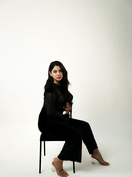 Adelie Fur Velvet Jumpsuit - seated full-length side shot, black - Miss Mosa By Akanksha