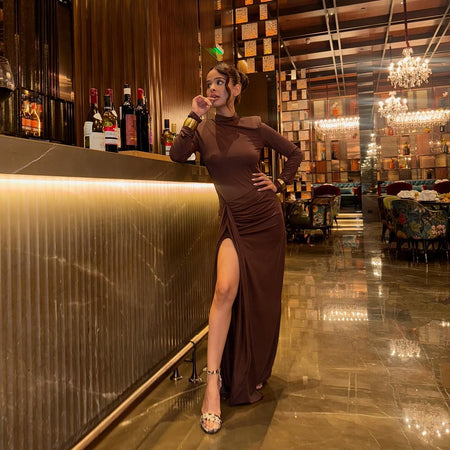 Alina Statement Slit Cut Maxi Dress In Brown - full-length side shot on model at a bar - Miss Mosa By Akanksha
