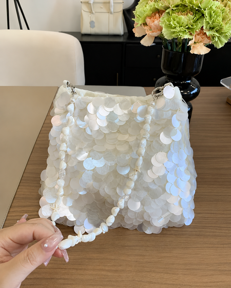 Belle Sequin Hand Bag With Chain - front shot held in hand, white iridescent paillette sequins with shell and pearl strap - Miss Mosa By Akanksha