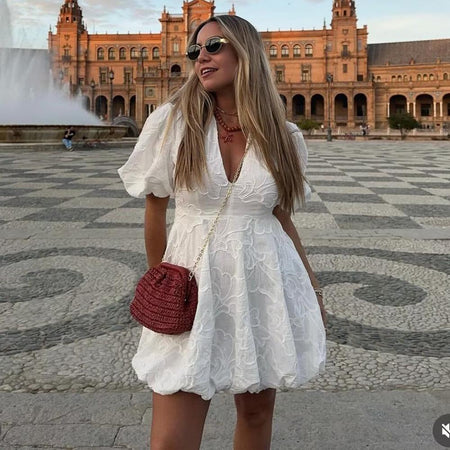 Carly Summer Holiday Dress In White - side shot on model carrying a handbag - Miss Mosa By Akanksha