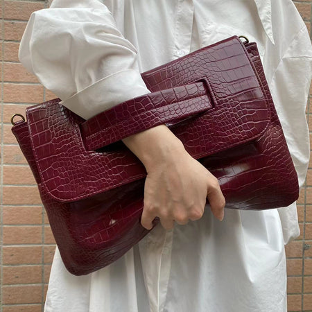 Cruz Textured PU Clutch Bag With Belt - handheld shot on model, burgundy - Miss Mosa By Akanksha