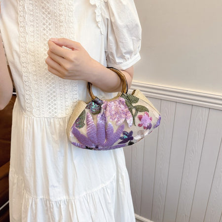 Dabel Embroidered Hand Bag - held shot on model, beige with lilac and pink floral sequins - Miss Mosa By Akanksha