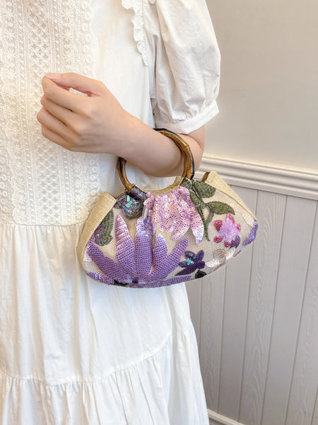 Dabel Embroidered Hand Bag - held shot on model, beige with lilac and purple floral sequins - Miss Mosa By Akanksha