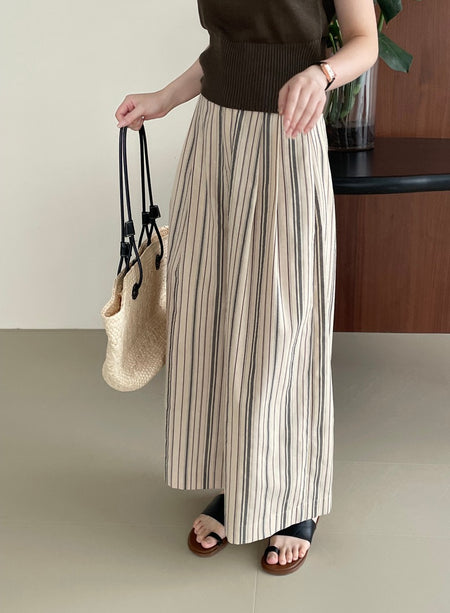 Elon Statement Striped Pants In Beige - side shot on model holding bag - Miss Mosa By Akanksha