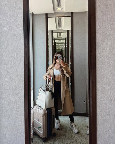 Essie Statement Premium Trenchcoat - mirror selfie on model with luggage, beige - Miss Mosa By Akanksha