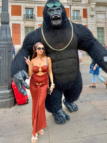 Freza Bodycon Maxi Dress In Rust - full-length shot on model posing with costumed mascot - Miss Mosa By Akanksha