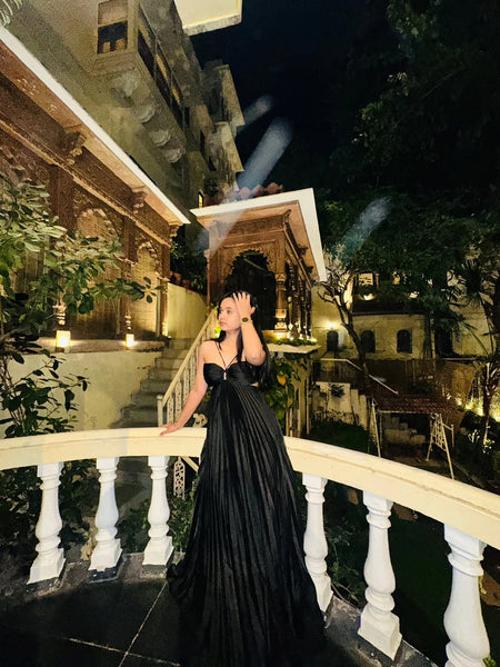 Hay Luxe Pleated Flowy Maxi Dress In Black - full-length front shot on model on a balcony at night - Miss Mosa By Akanksha