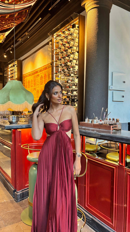 Hay Luxe Pleated Flowy Maxi Dress In Maroon - full-length front shot on model at a bar - Miss Mosa By Akanksha