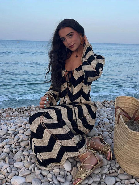 Jerrica Soft Knit Holiday Dress In Black - seated shot on model at beach - Miss Mosa By Akanksha
