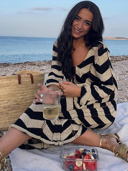 Jerrica Soft Knit Holiday Dress In Black - seated shot on model at beach - Miss Mosa By Akanksha