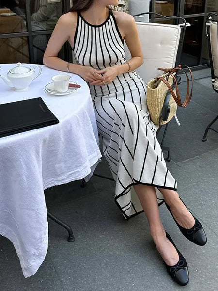 Lavinia Striped Holiday Dress In White - styling shot on model seated outdoors - Miss Mosa By Akanksha