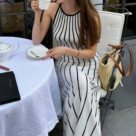 Lavinia Striped Holiday Dress In White - styling shot on model seated outdoors - Miss Mosa By Akanksha