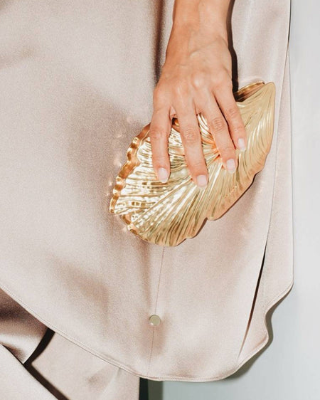 Leaf Clutch Bag With Chain - handheld close-up shot on model, gold - Miss Mosa By Akanksha