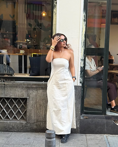 Maisie Offshoulder Holiday Tube Dress In Beige - full-length front shot on model at a cafe - Miss Mosa By Akanksha