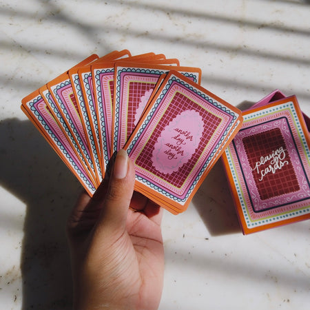 Miss Mosa Playing Cards- Diwali Edition - in-hand shot of fanned cards beside box, multicolour pink and orange - Miss Mosa By Akanksha
