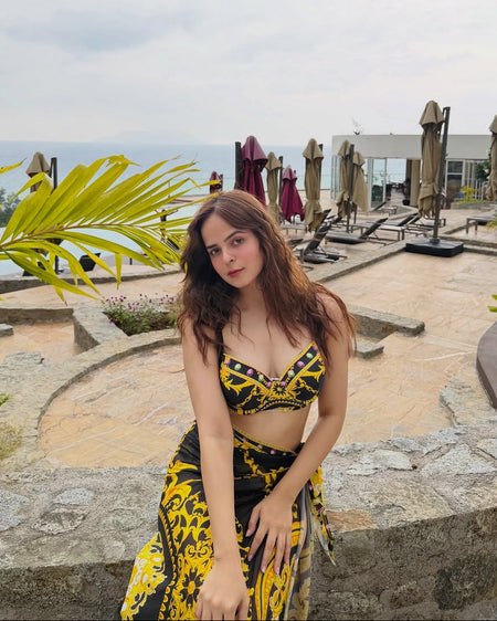 Morocco Swimsuit With Sarong Skirt In Black - seated front shot on model outdoors - Miss Mosa By Akanksha