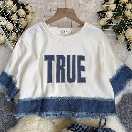 Noemi Knitted Soft Denim Co-ord Set In White - close-up of frayed denim hem and front print - Miss Mosa By Akanksha