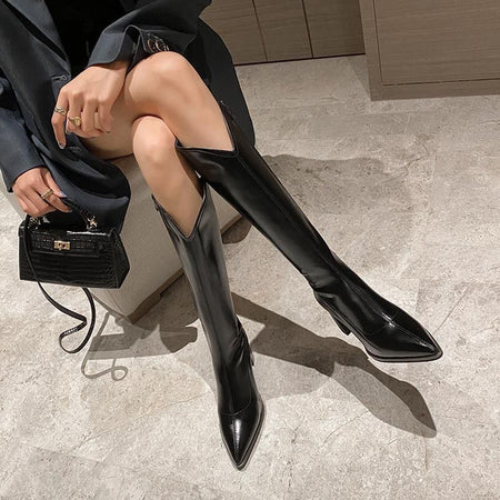 Rhodes Knee High Pointed Leather Boots - seated front shot on model with handbag, black - Miss Mosa By Akanksha