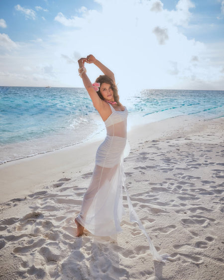 Senna Bodycon Slit Maxi Dress In White - styling shot on model on beach - Miss Mosa By Akanksha