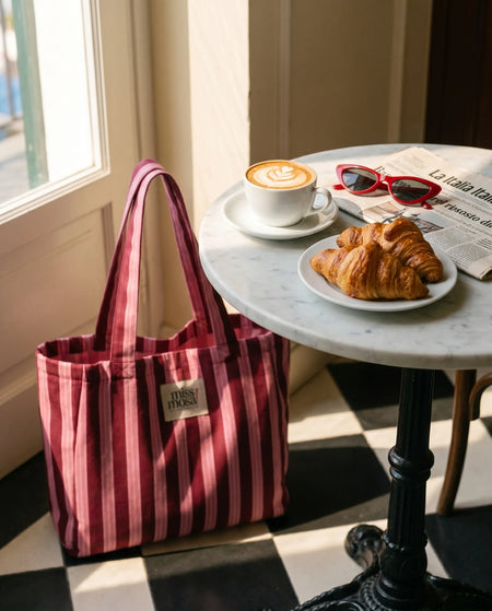 The Miss Mosa Tote Bag - Pink Striped - styled lifestyle shot beside cafe table, pink and maroon striped - Miss Mosa By Akanksha