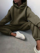 Varya Statement Tracksuit - seated shot on model, olive green - Miss Mosa By Akanksha
