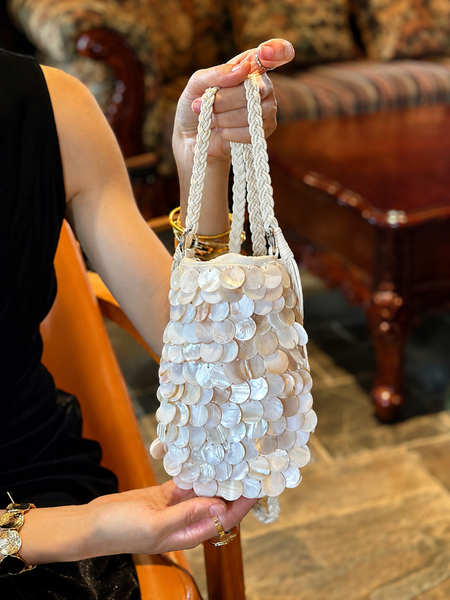 Zoey Shell Sling Bag - shot of bag held by model, cream and mother-of-pearl with braided cream strap - Miss Mosa By Akanksha